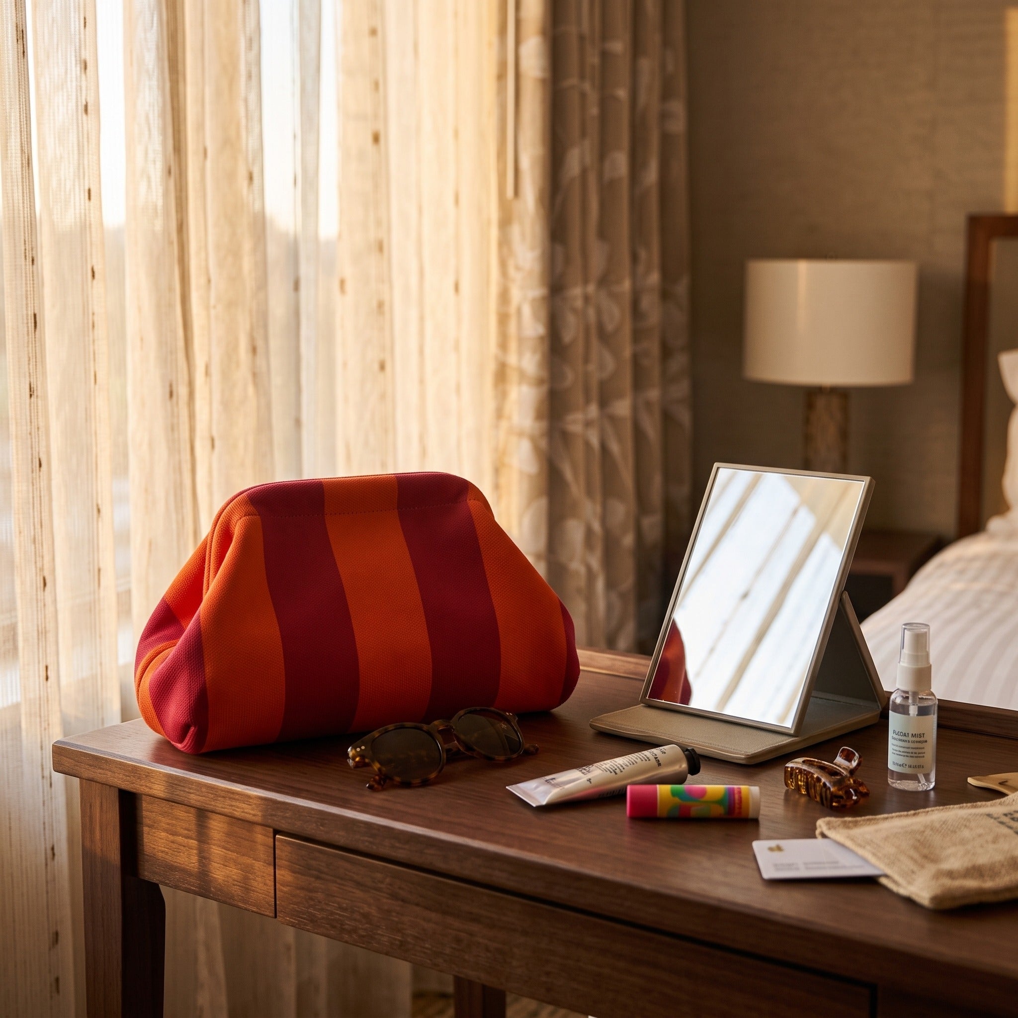Red and orange Pop Pouch on a hotel dressing table