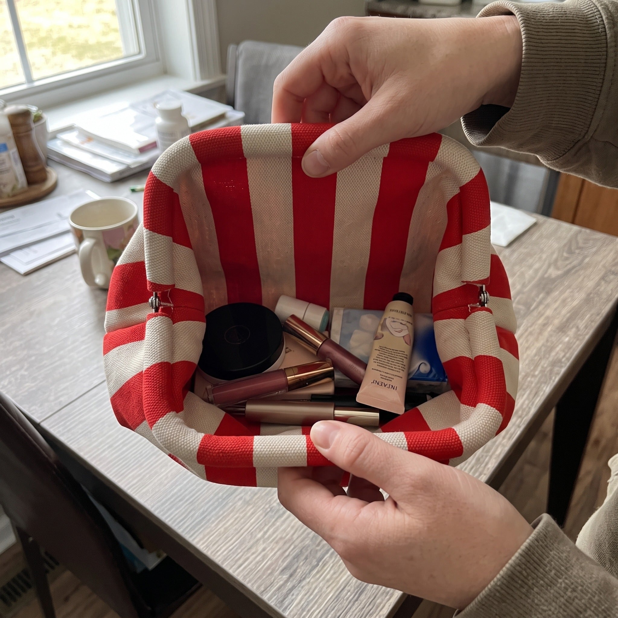 Red and white Pop Pouch held open with makeup inside
