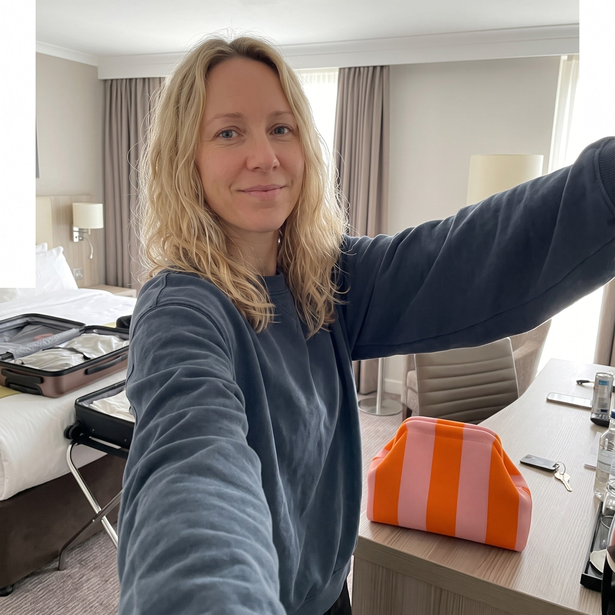 Olivia K. with orange and pink Pop Pouch at a hotel