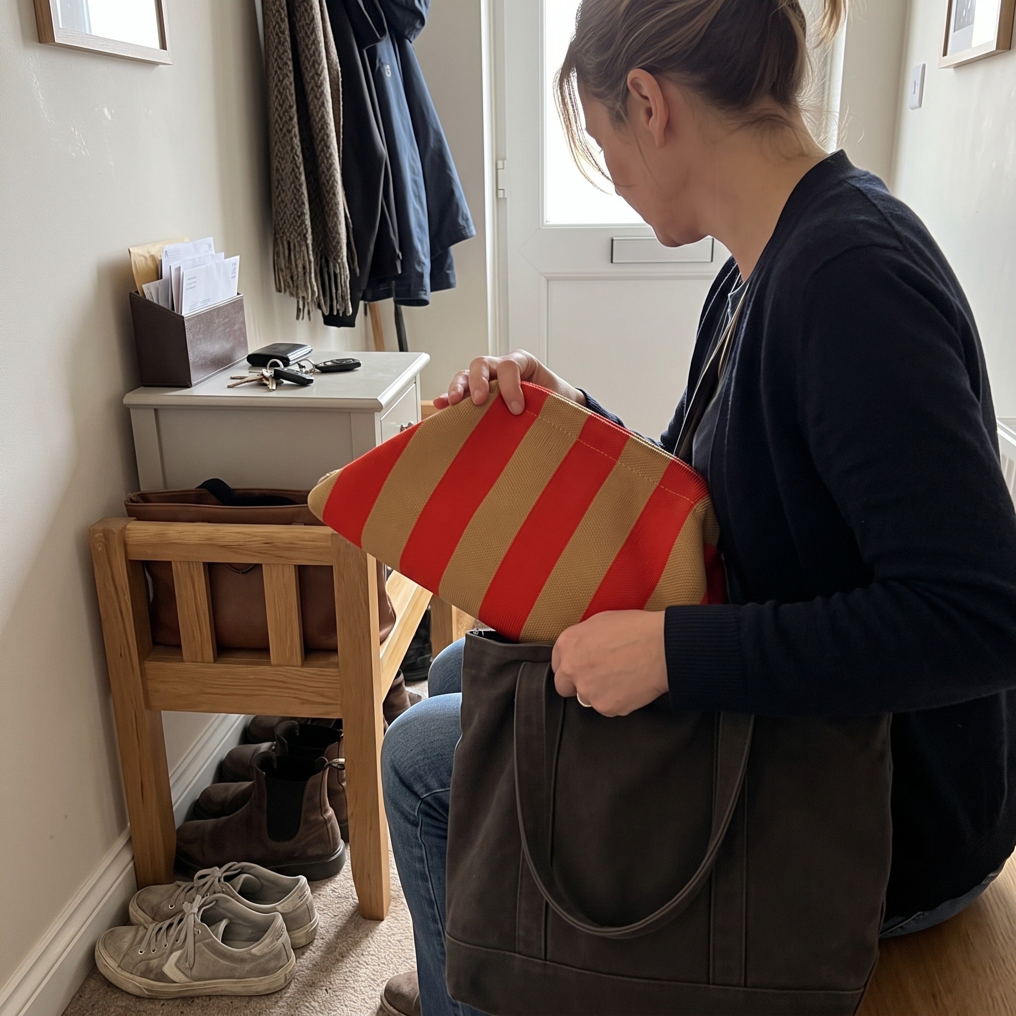 Red and beige Pop Pouch being placed in a tote