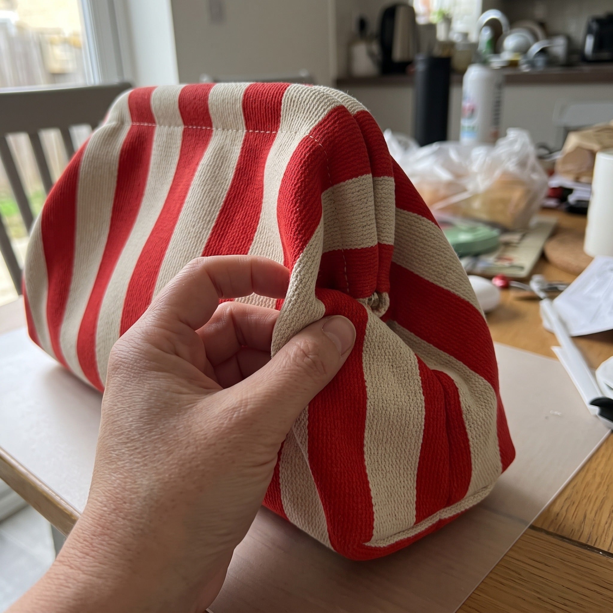 Fingers holding the red and white spring-frame end
