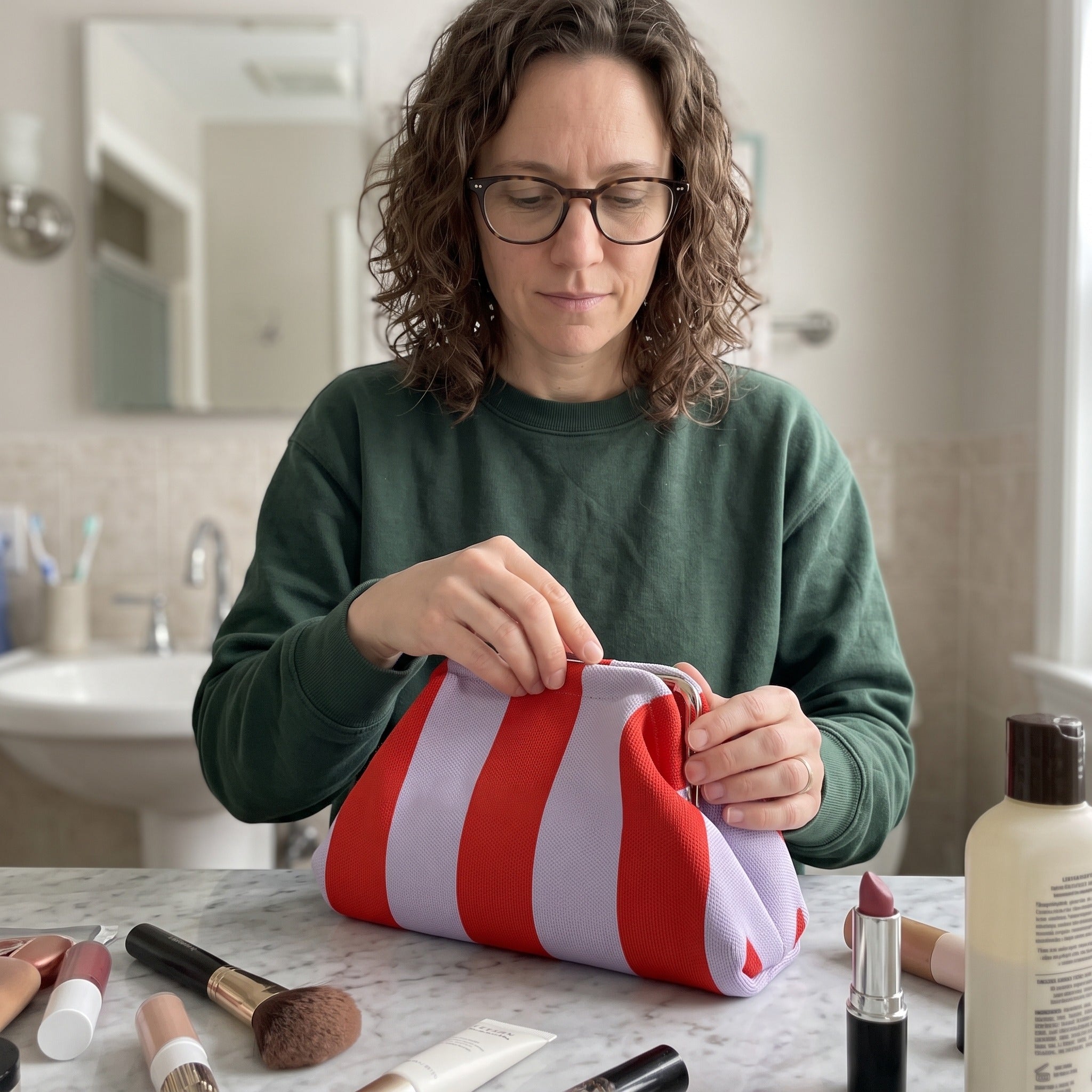 Owner scene with a striped Pop Pouch makeup bag
